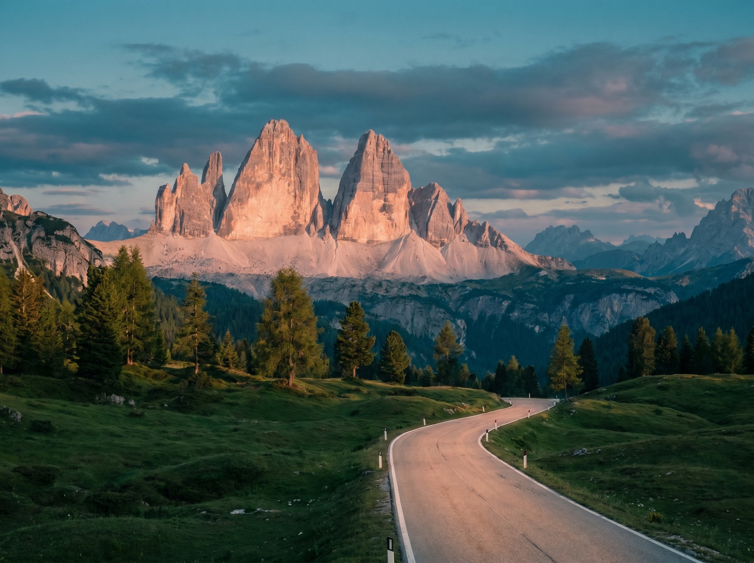 A dramatic alpine pass road below pale peaks