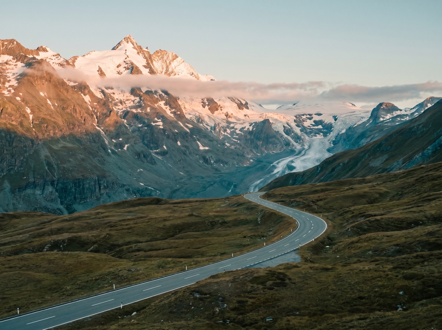 A grand alpine road sweeping toward a glacier